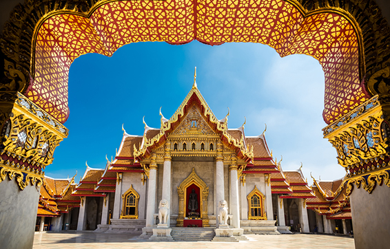 golden bangkok temple with lion statues in sunshine